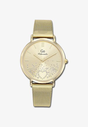 Montre avec bracelet en maille dorée, à cadran rond, indicateurs horaires clairs, et un design scintillant arborant un dégradé de petits cristaux en bas.