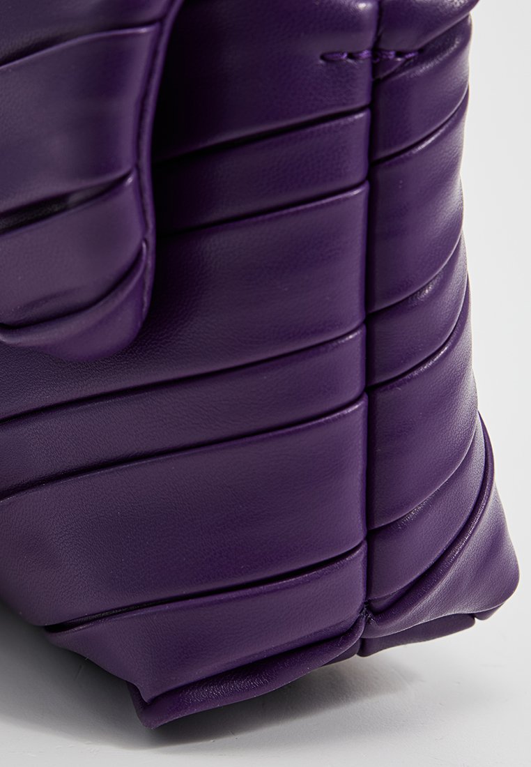Borsa in pelle viola con una texture trapuntata, caratterizzata da pieghe orizzontali e bordi lisci per un aspetto strutturato ma morbido.