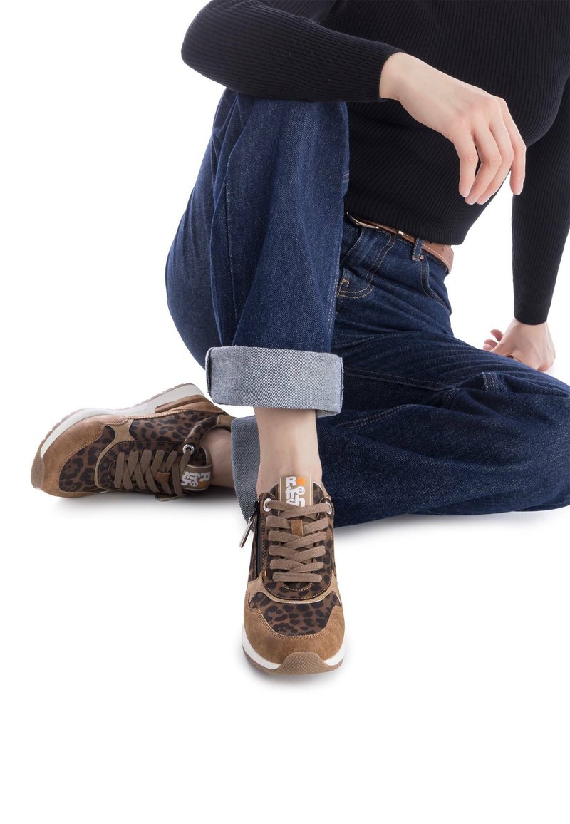 Zapatillas de deporte con estampado de leopardo marrón, confeccionadas con materiales de ante y malla, que cuentan con cordones marrones, una suela texturizada y un parche de logo naranja.