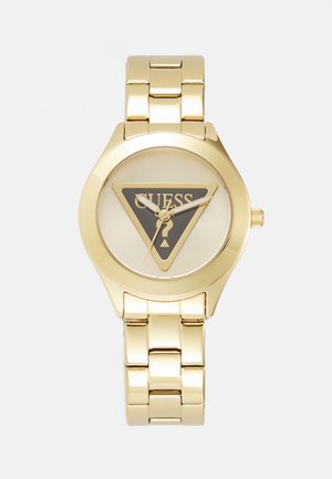 Gold metal watch with a round case, featuring a triangular black dial with "GUESS" logo and gold hands on a linked bracelet.