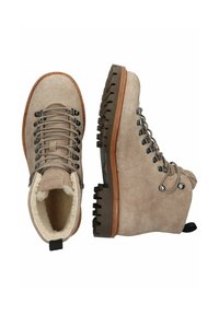 Botas de senderismo de ante beige con suelas de goma gruesas, ojales de metal, cordones beige y un cálido forro de piel de oveja en el interior.