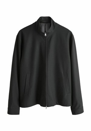 Schwarze Reißverschlussjacke mit Stehkragen, zwei Seitentaschen und einer glatten, matten Textur. Einfaches Design und gerade geschnittene Silhouette.