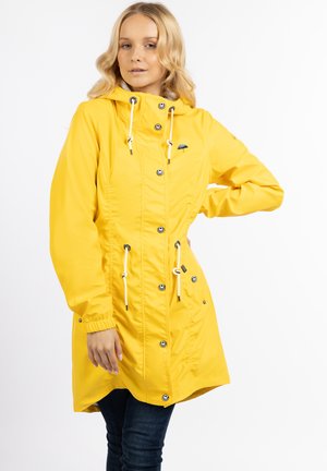 Geel waterdicht regenjack met een capuchon, voorste drukknoopsluiting, koord in de taille en elastische manchetten. Zachte textuur en logo-detail op de borst.