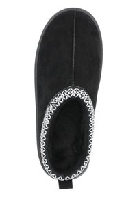 Svart mockaskor med rundad form, som har en mysig inredning, vit broderad kant runt öppningen och en platt texturerad sula.