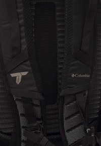 Czarny plecak z siateczkowym panelem tylnym, regulowanymi paskami i detalami marki, w tym srebrnym logo i metką Columbia.