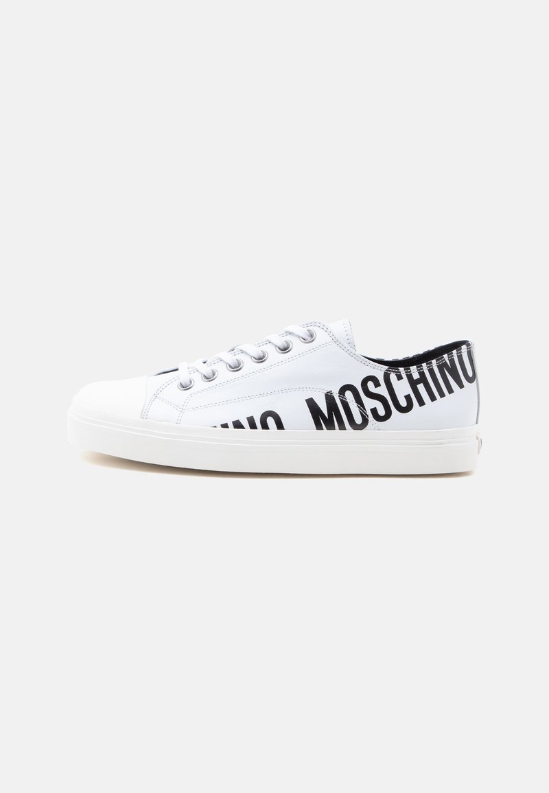 Λευκό χαμηλό sneaker με λευκά κορδόνια και μαύρο κείμενο "MOSCHINO" μερικώς ορατό στο πλευρό και στη φτέρνα.