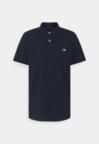 Polo bleu marine en coton. Il présente un col avec deux boutons, des manches courtes et un petit logo brodé sur le côté gauche de la poitrine.