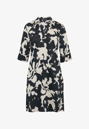 Zwart-witte bloemenprint jurk met een kraag, driekwart mouwen en zijzakken. Gemaakt van een lichte stof met een zachte textuur.