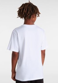 Vit bomull t-shirt, kort ärm, rundad halsringning, rak skärning. Slät textur, enkelt design, inga utsmyckningar eller mönster.