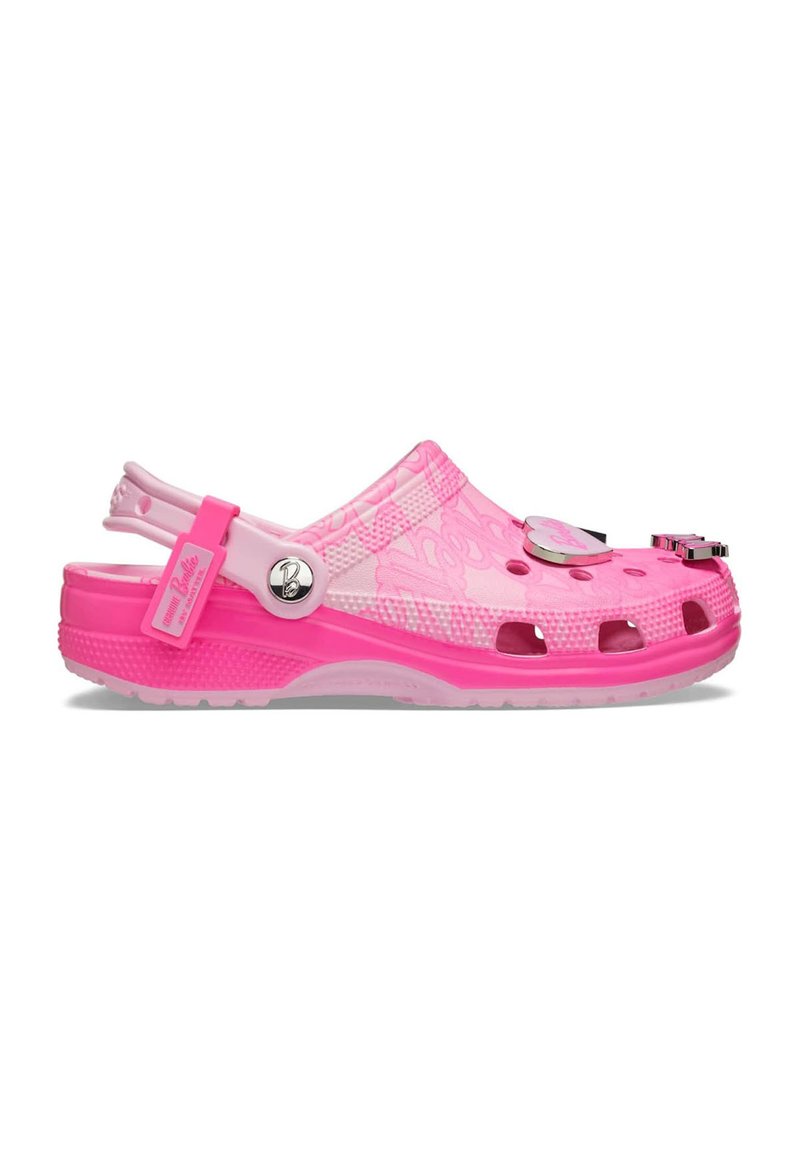 Zoccolo di plastica rosa con design aperto, dotato di fori di ventilazione, cinturino per il tallone regolabile e charm decorativi sulla parte superiore.