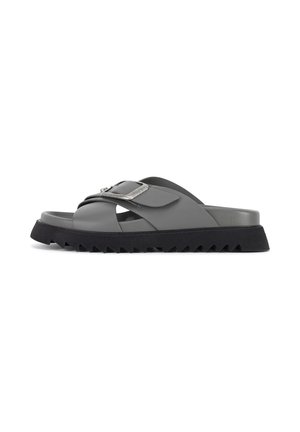 Gray synthetic slide sandal with a wide strap and a silver-tone buckle. Features a thick black zigzag sole for traction.