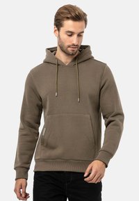 Olivgrüner Kapuzenpullover mit einer Fronttasche und Kordelzügen. Hergestellt aus glattem, strukturiertem Stoff mit gerippten Bündchen.