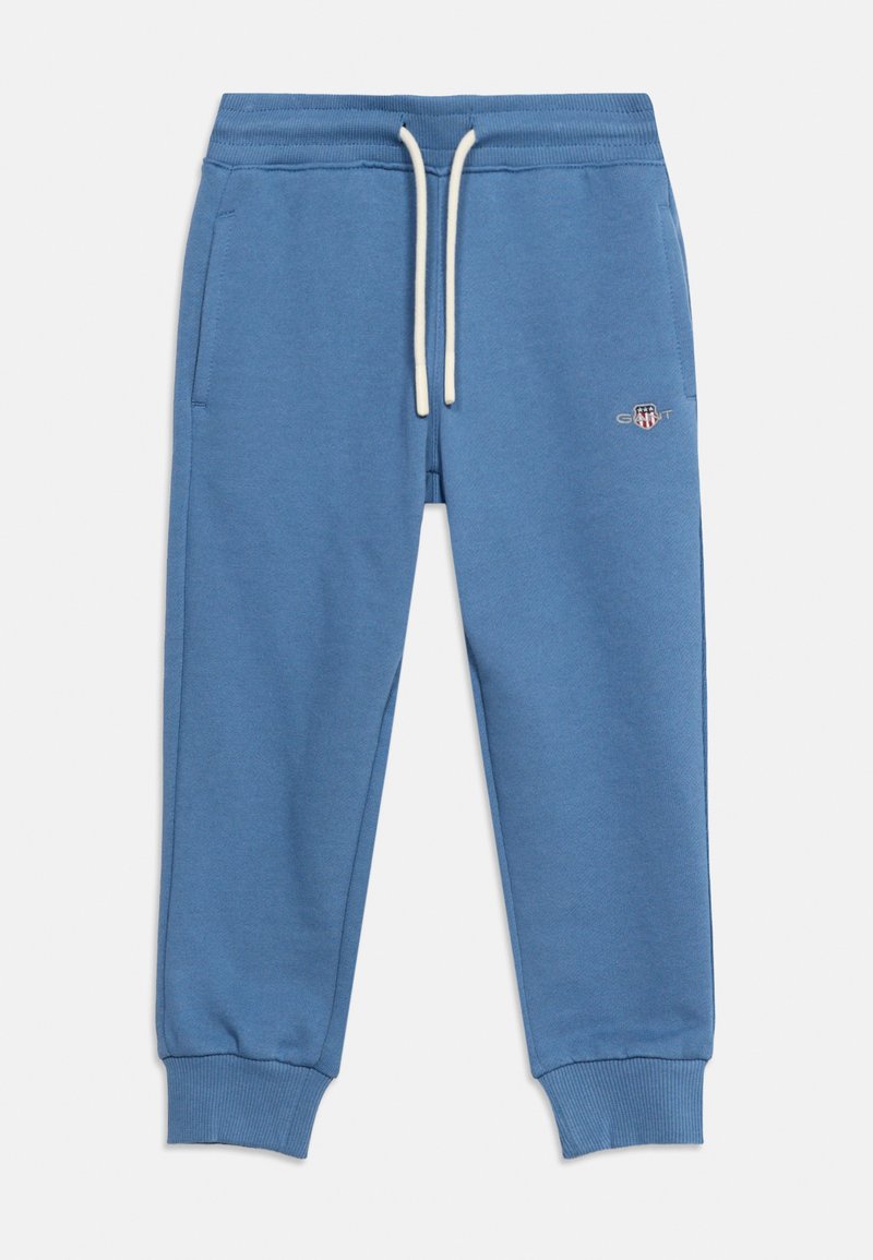 Μπλε φόρμα με ελαστική μέση, λευκά κορδόνια, πλαϊνές τσέπες, ριμπ μανσέτες στους αστραγάλους και μικρό κεντημένο λογότυπο στο αριστερό μηρό.