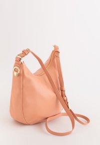 Bolso de cuero melocotón con una silueta curva, cremallera dorada, correa ajustable y un acento de hardware decorativo en el lateral.