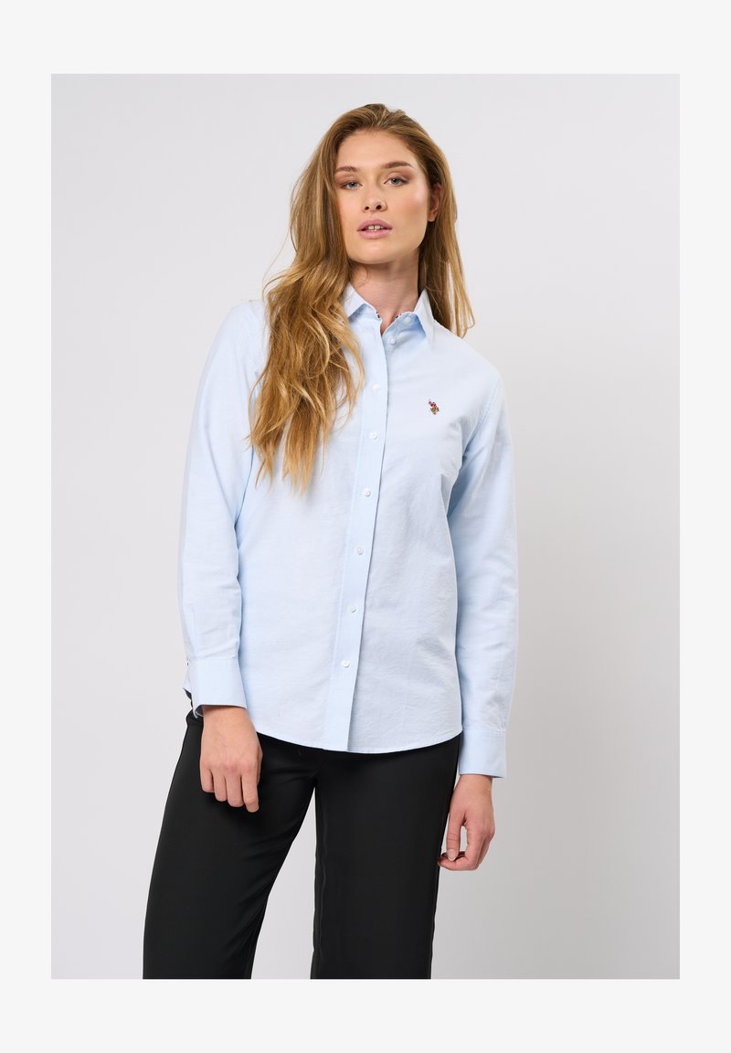 Svetlo modra srajca z dolgimi rokavi in pointed ovratnikom. Ima majhen vezen logotip na prsih, izdelana iz mehkega blaga.