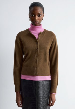 Brown, button-up cardigan over a pink turtleneck, featuring long sleeves and a simple design. Black textured pencil skirt completes the outfit.