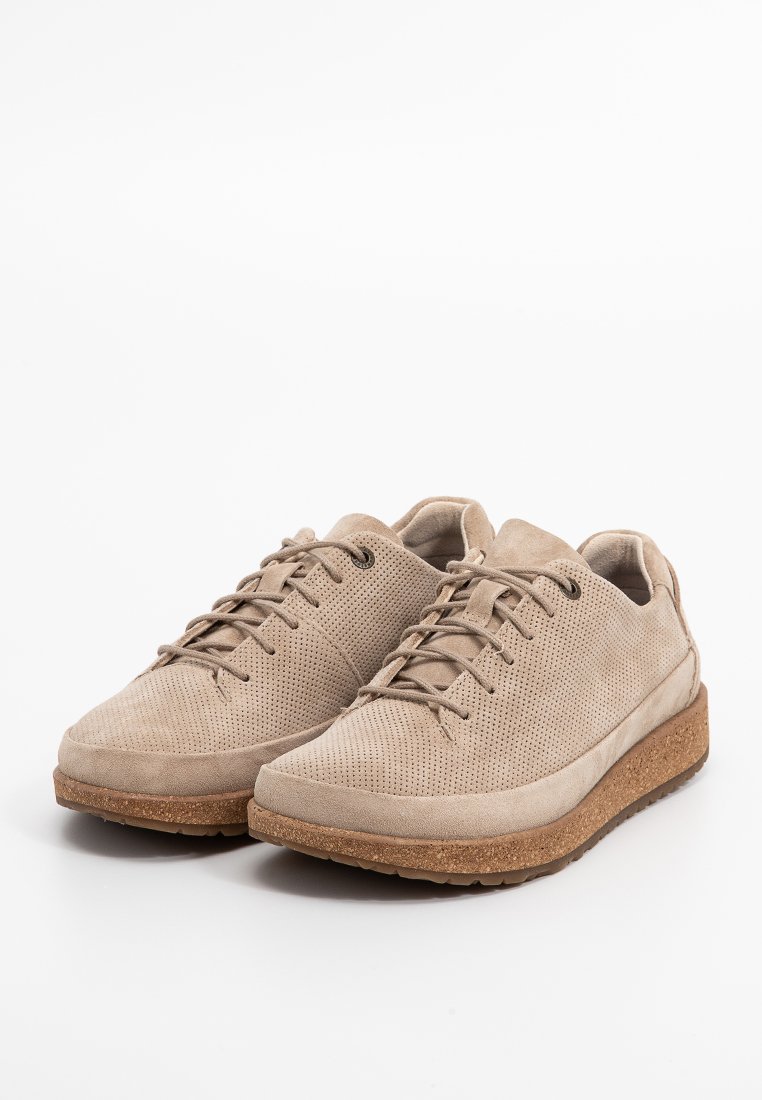 Beige sneakers met een textuur van suede bovenwerk, perforaties voor ademend vermogen en een dikke kurken zool. Klassiek vetersluiting ontwerp.