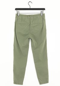 Zelené kalhoty z bavlněné směsi s elastickým pasem a dvěma zadními kapsami. Hladká textura, design zúžených nohavic, zavěšené na černém háčku.