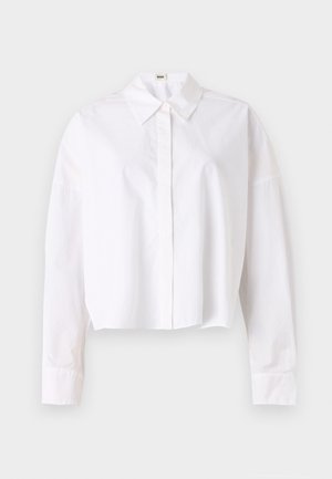 Valkoinen lyhytcropped-paita, joka on tehty puuvillasta, klassisella kauluksella, napituksella edessä ja pitkillä hihoilla, joissa on cuffit. Sujuva rakenne, yksinkertainen muotoilu.