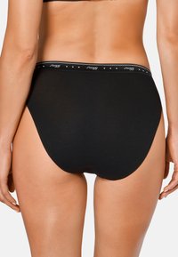 Schwarze Baumwollunterwäsche mit hohem Schnitt und weichem Bund, der dezente Markenkennzeichnung aufweist. Glatte Textur und minimalistischer Stil.