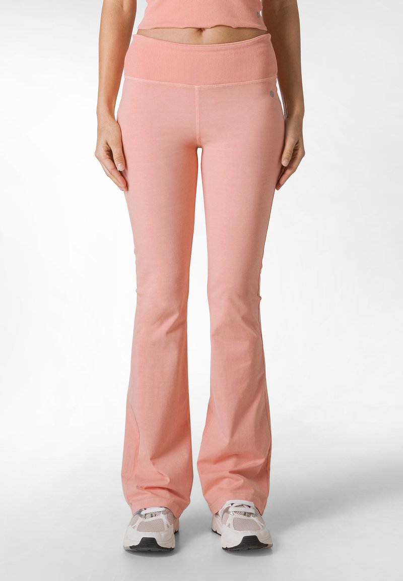 Lichtroze flared broek van zachte stof, met een brede geribbelde tailleband en naadloze zijdetails.