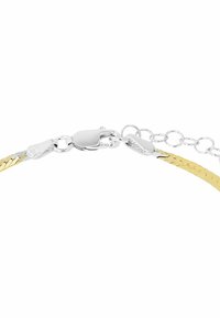 Flätad armband av guld och silver med ett skinnande metallspänne. Har sammankopplade länkar och strukturerad yta. Justerbar längd.