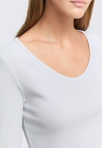 Lichtgrijze geribbelde top met een brede ronde halslijn, met textuurstof en een aansluitend ontwerp.