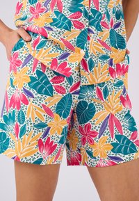 Pantalones cortos de estampado floral en mezcla de algodón. Presenta colores vibrantes: azul verdoso, rosa, amarillo y púrpura. Decorados con grandes hojas y flores.