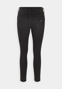 Jean skinny en denim noir avec taille haute, dotés de deux poches arrière et d'un ourlet effiloché au niveau des chevilles. Couleur unie et propre avec un minimum de détails.