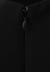 Prim-plan al unui fermoar negru parțial închis pe o țesătură neagră texturată, evidențiind cursorul fermoarului și dinții care se încuie.