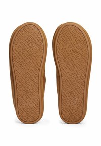Sohleansicht von braunen Slip-On Hausschuhen mit strukturierten Sohlen, die ein sich wiederholendes "Tommy Hilfiger"-Textmuster aufweisen.
