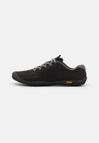 Scarpe sportive in suede nero con accenti grigi, dotate di una suola testurizzata e marchio Vibram. Design con lacci e profilo basso.