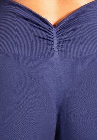 Leggings bleu marine sans couture avec un design côtelé texturé, une taille froncée et une coupe cintrée, mettant en valeur la silhouette et le confort.