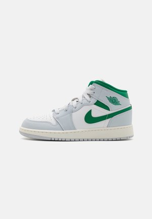 Hvid og grå midt-top sneaker med grøn Nike swoosh, grøn ankelkrave, hvide snørebånd og Air Jordan Wings-logo på siden.