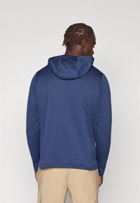Granatowy hoodie z długim rękawem, wykonany z teksturowanej tkaniny, z kapturem na sznurki i prostym dołem. Charakteryzuje się luźnym krojem i mieszanym materiałem.