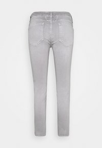 Harmaat farkut, joissa on slim fit -malli, litteä vyötärö, viisi taskua ja vaaleat tikkaukset. Sileä pinta ja minimalistinen muotoilu.