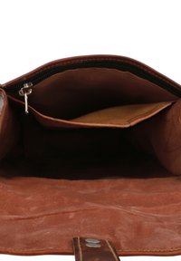 Unutrašnjost smeđe kožne torbe s džepom na patnentu i odvojenim otvorenim džepom. Meka tekstura i minimalistički dizajn.