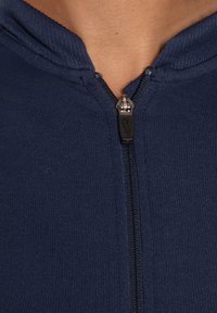 Sudadera con cremallera en azul marino, con tejido acanalado, cremallera frontal con un tirador negro y capucha con cordón.