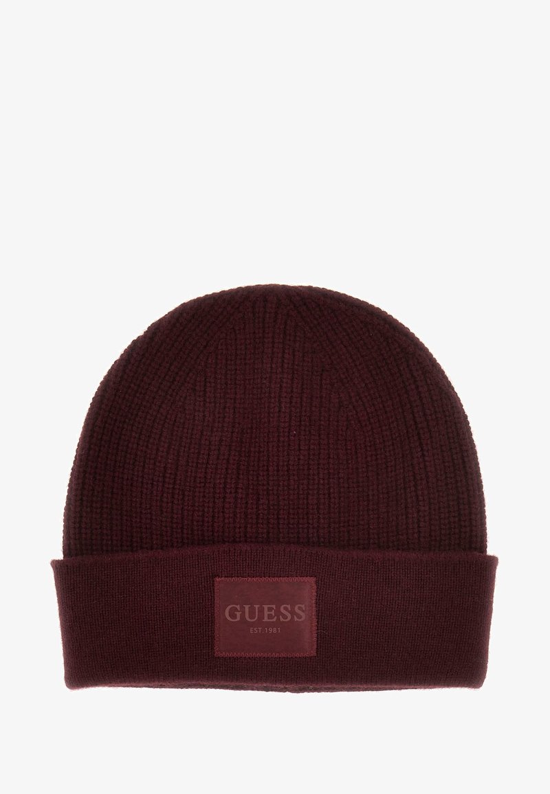 Burgunderfarbene gerippte Strickmütze mit umgeschlagenem Saum und aufgenähtem rechteckigem Patch, auf dem "GUESS EST. 1981" in der Mitte vorne steht.