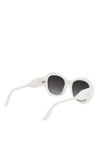 Lunettes de soleil en plastique blanc avec un design audacieux et surdimensionné en forme d'œil de chat. Verres gris foncé et branches plates et larges présentant un accent de logo.