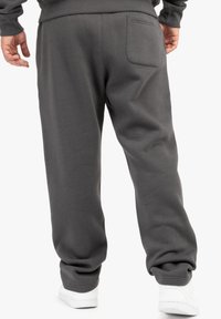 Grå sweatpants lavet af blødt materiale, med elastiske manchetter, en baglomme og en afslappet pasform for komfort.
