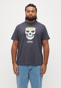 Σκούρο γκρι βαμβακερό μπλουζάκι με μεγάλο λευκό γραφικό κρανίου με κίτρινη λεπτομέρεια στο πάνω μέρος, στρογγυλή λαιμόκοψη και κοντά μανίκια.