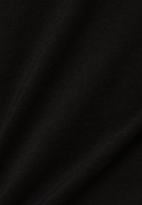 Tissu en coton noir avec une texture lisse et un motif en fines côtes, affichant des variations subtiles de lumière et d'ombre.