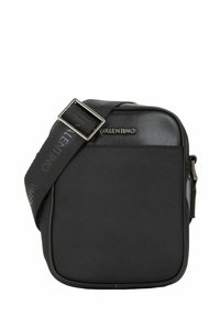 Sacoche noire à forme structurée, fabriquée en matériau texturé, avec un logo sur le devant et une bandoulière réglable.