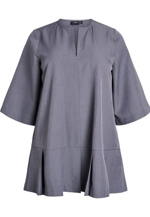 Grå tunika med rund halsringning, korta trumpetärmar och en lager-på-lager fåll. Tillverkad av ett mjukt, strukturerat tyg med ett subtilt mönster.