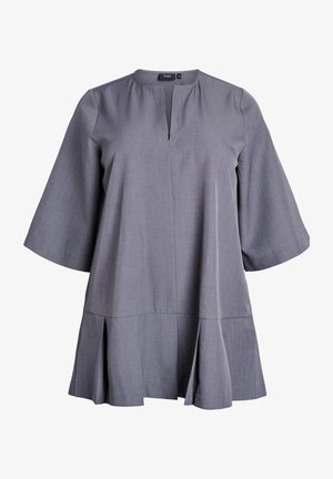 Túnica gris con un escote redondo, mangas cortas de campana y un dobladillo en capas. Hecha de una tela suave y texturizada con un patrón sutil.