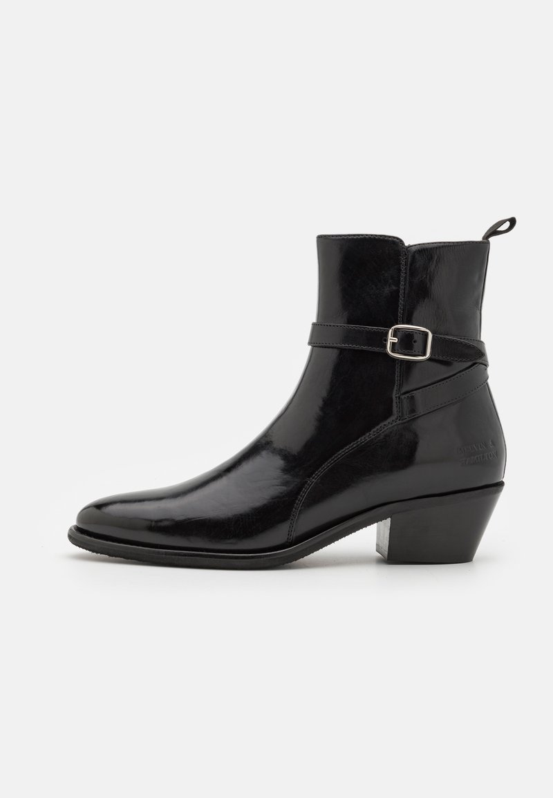 Bocanc de gleznă din piele neagră cu un finisaj lucios, vârf ascuțit și toc mic blocat. Prezintă un detaliu decorativ cu curea și cataramă.