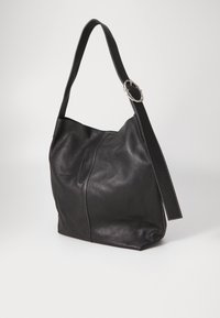 Saco de ombro de couro preto com uma textura lisa, forma curva e uma alça larga com detalhes em hardware prateado e costura branca.