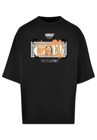 Camiseta oversized negra con un gráfico de un billete de dólar y la palabra "WASTED" en pintura en spray naranja, impresa en la parte frontal.