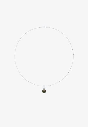 Collier chaîne argentée avec petit pendentif rond noir centré, présenté sur un fond blanc.